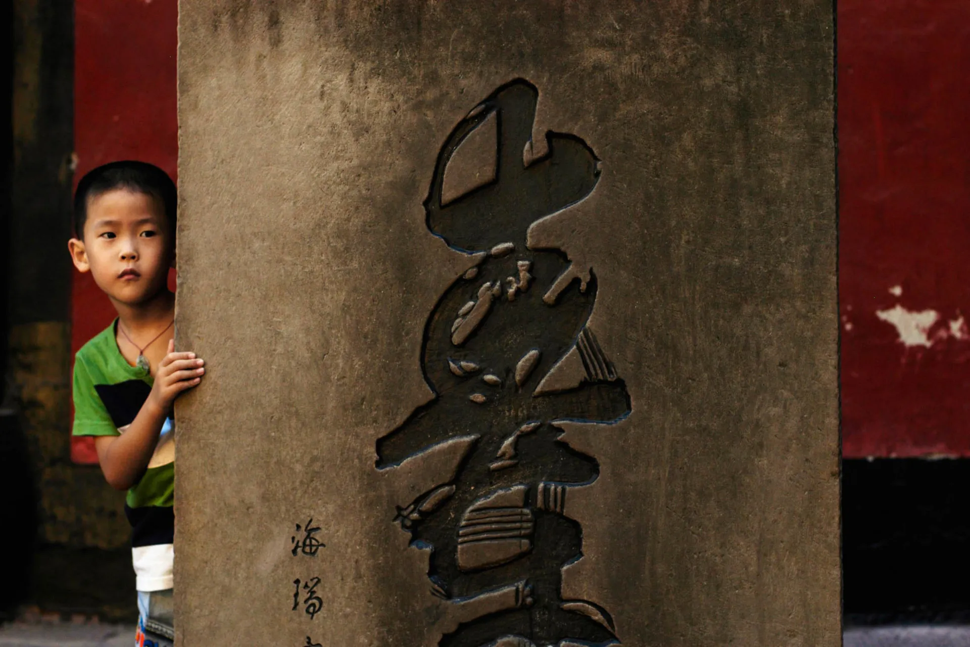 Chłopiec przy kolumnie – napis „góra” po chińsku Chłopiec przy kolumnie – napis „góra” po chińsku