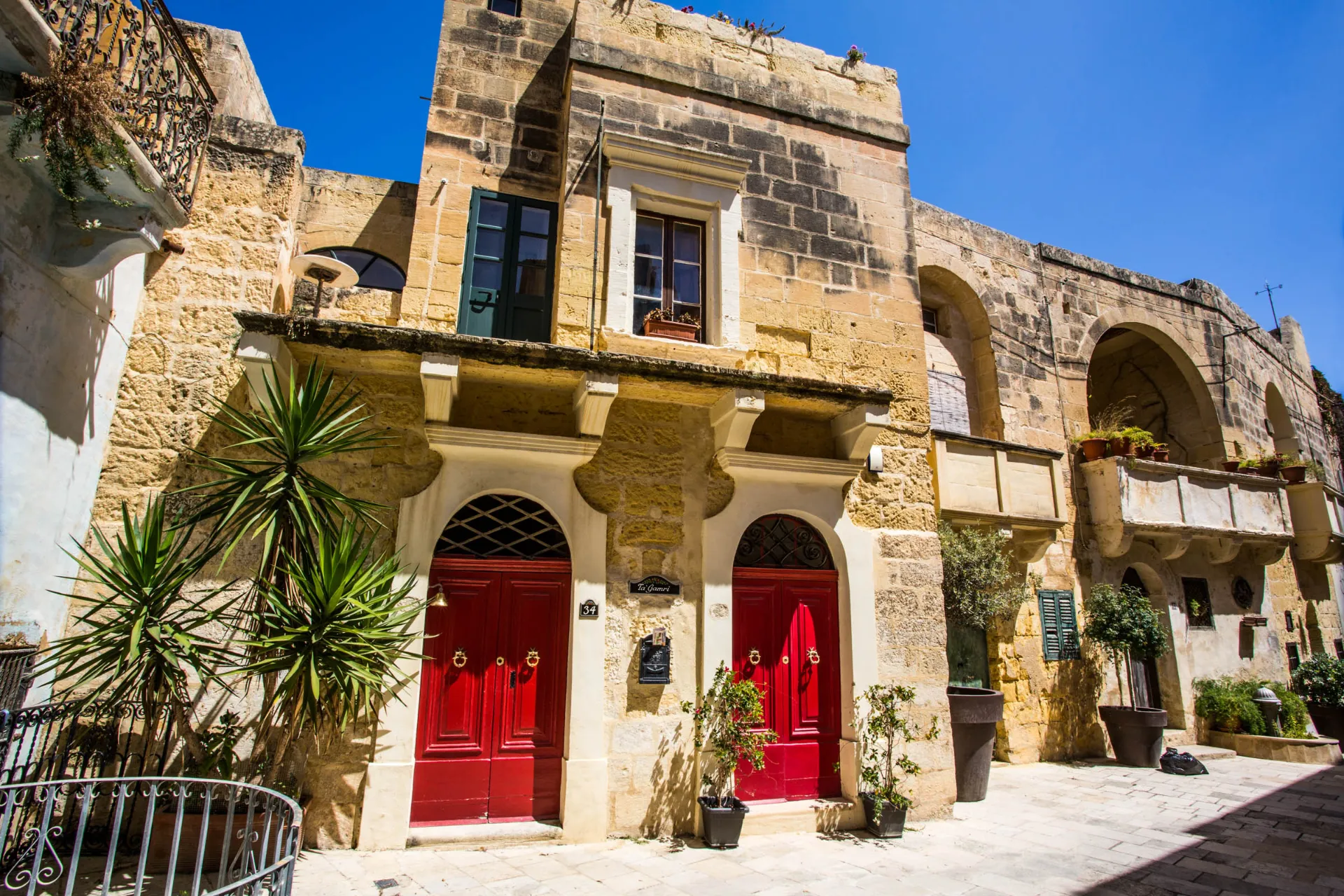 Urocze kamienne domy z czerwonymi drzwiami w Victorii na Gozo Urocze kamienne domy z czerwonymi drzwiami w Victorii na Gozo