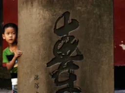 Chłopiec przy kolumnie – napis „góra” po chińsku Chłopiec przy kolumnie – napis „góra” po chińsku